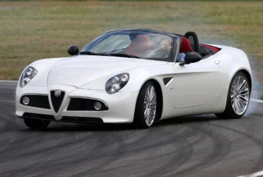 Alfa Romeo 8C Spider לבנה עם גג פתוח ומושבים אדומים בנסיעה