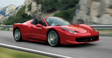 Ferrari 458 Spider אדומה עם גג פתוח בנסיעה בכביש הררי