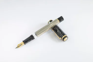 עט נובע Omas Cobra בכסף סטרלינג עם גוף מתומן, עיטורי קשקשים וחלקים שחורים בגימור זהב